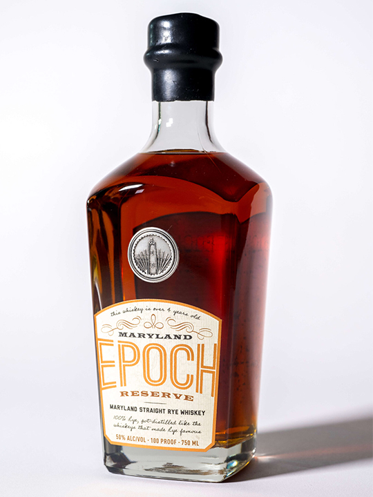A bottle of Maryland Epoch Reserve straight rye whiskey by Baltimore Spirits Company, featuring amber liquid, a gold and white label, and a black cap, shown against a plain white background.