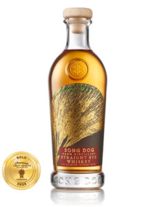 A bottle of Song Dog Farm Distillery Straight Rye Whiskey with a gold seal for a 2026 Craft Spirits Award. The label, reminiscent of the artistry seen in Baltimore Spirits Company releases, features an illustration of rye stalks.